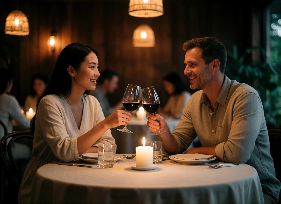 Asian woman and Western man sharing a toast at a candlelit restaurant table